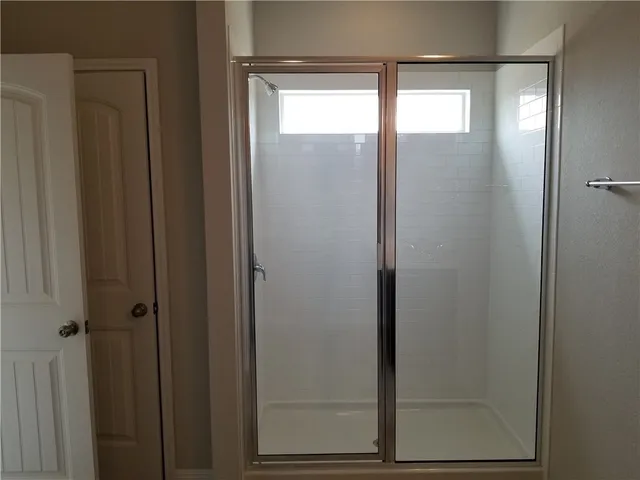 a bathroom with a glass shower door