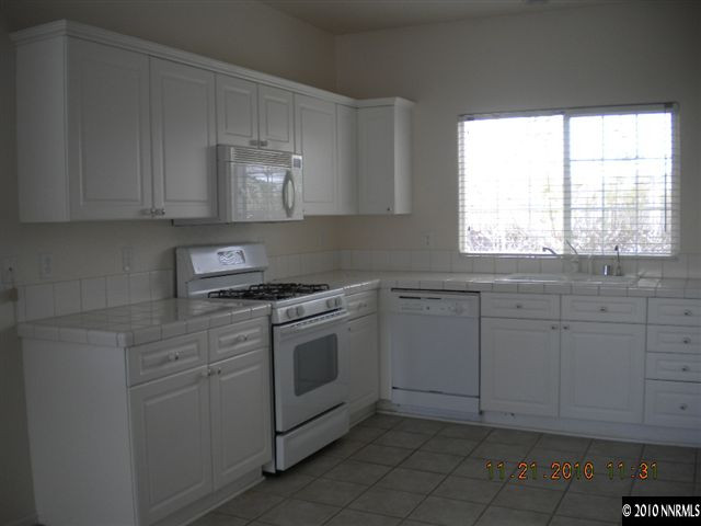 1764 Trek Trail Reno, NV 89521 - Photo 2 of 11 a kitchen with granite countertop white cabinets and white appliances