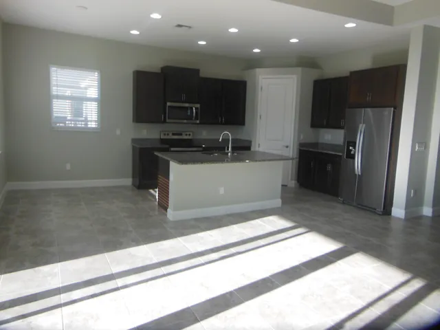 a view of a kitchen with a sink a refrigerator and window