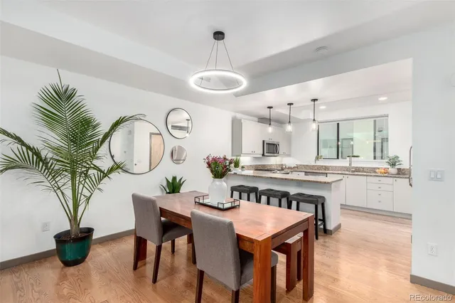 a kitchen with stainless steel appliances granite countertop a table chairs and white cabinets