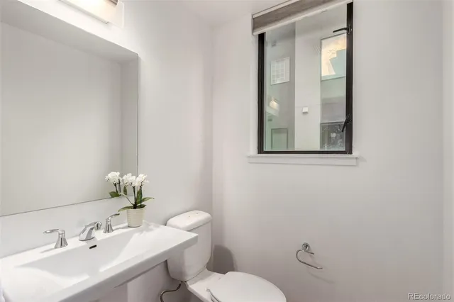 a bathroom with a toilet a sink and mirror