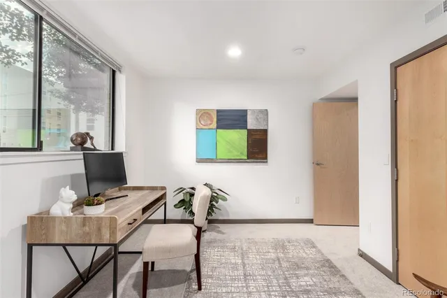 a view of a workspace with furniture and a window