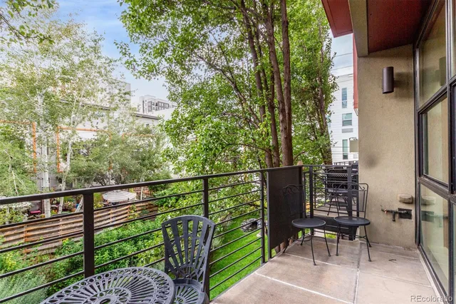a view of a balcony with chairs and wooden fence