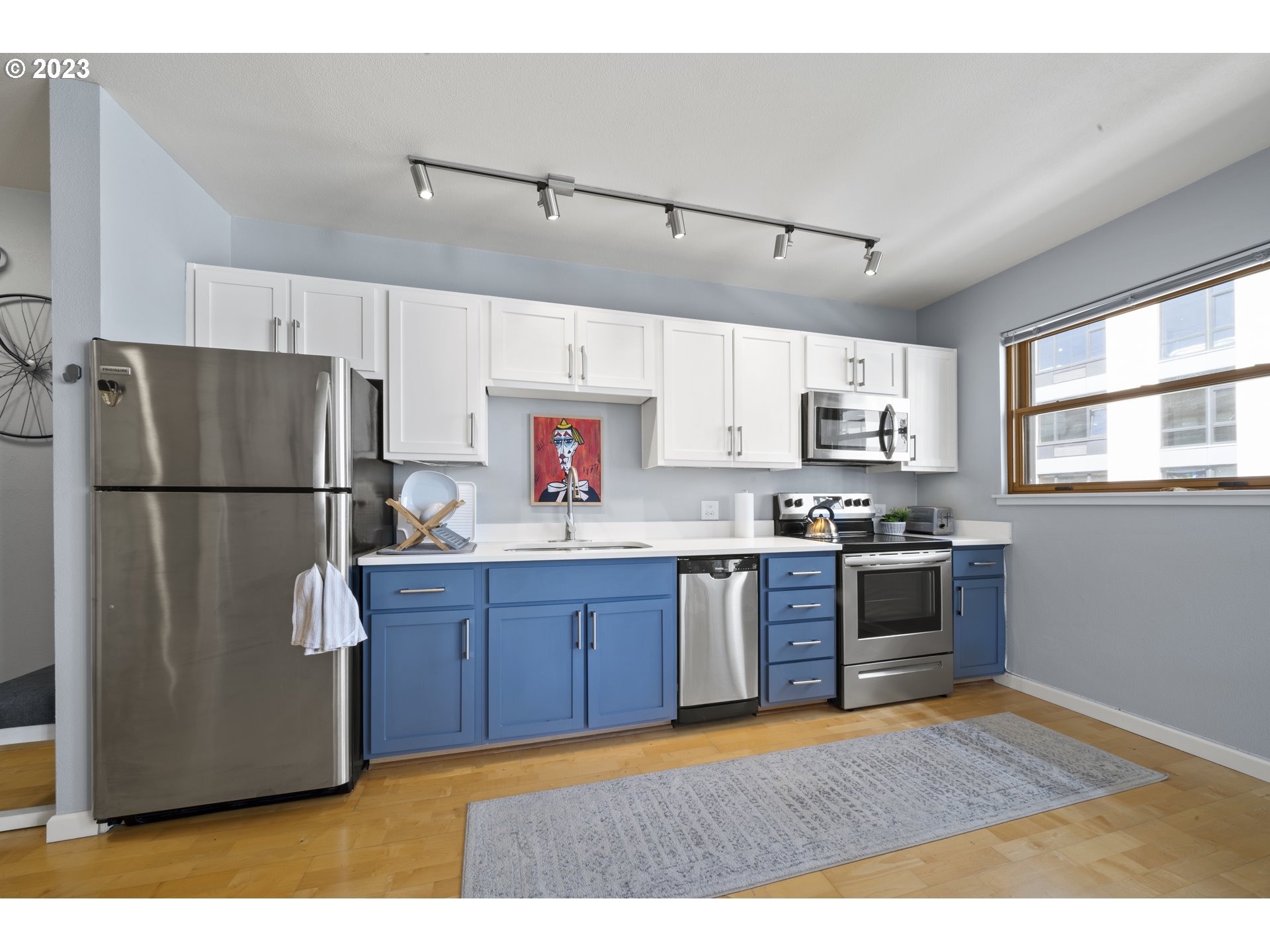 1134 Southwest Jefferson Street, Unit 405 Portland, OR 97201 - Photo 4 of 28 a kitchen with stainless steel appliances granite countertop a refrigerator stove a sink dishwasher and a refrigerator