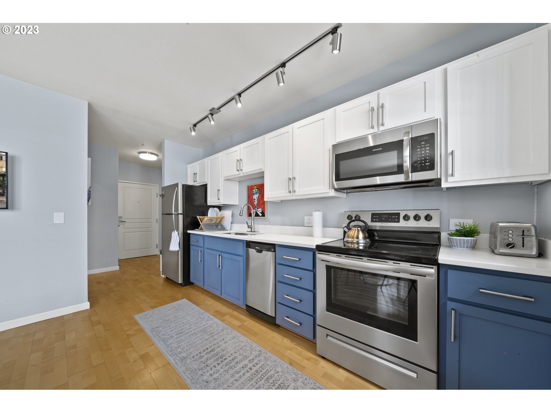 1134 Southwest Jefferson Street, Unit 405 Portland, OR 97201 - Photo 6 of 28 a kitchen with stainless steel appliances granite countertop a stove top oven a sink dishwasher and white cabinets