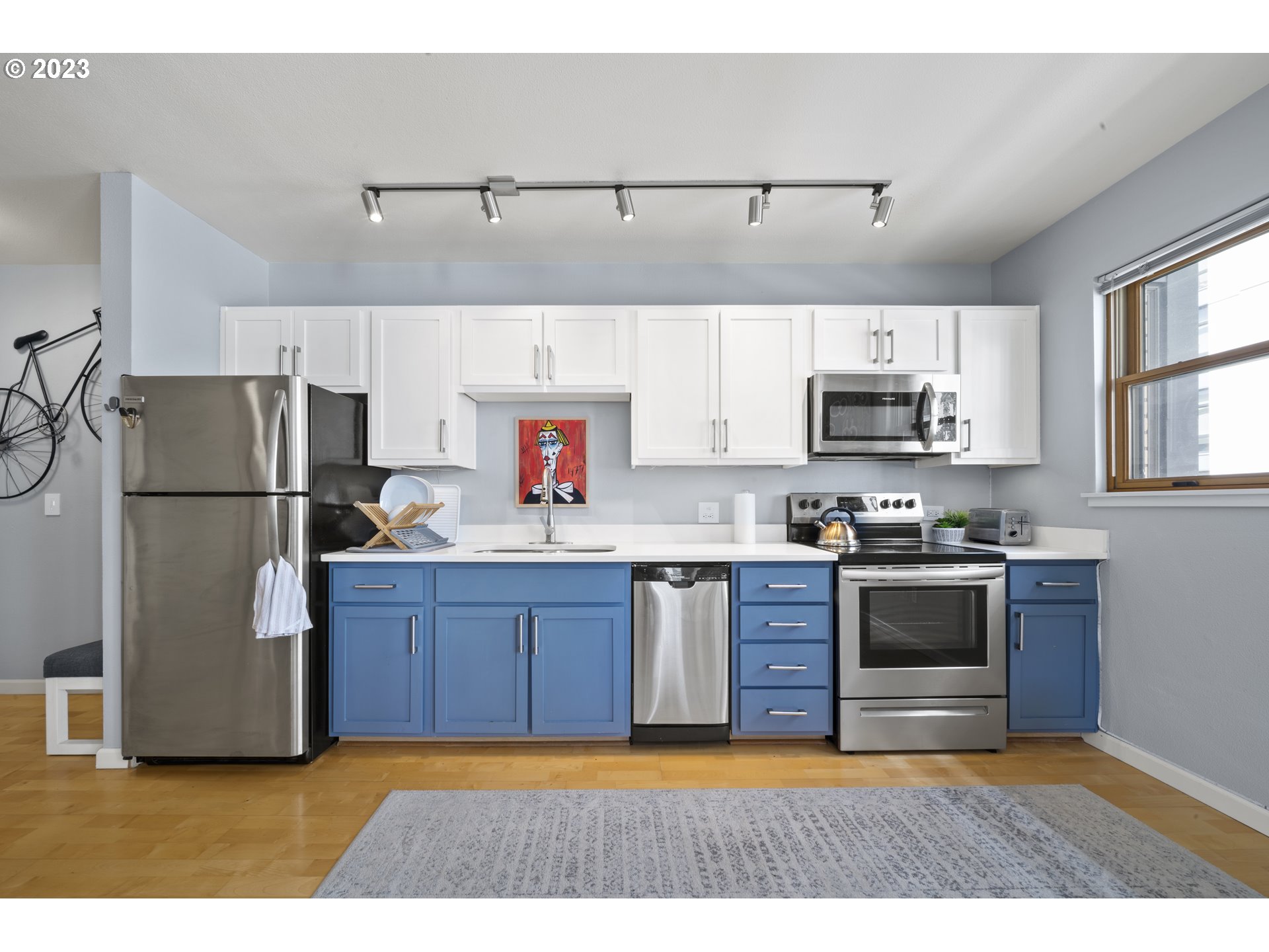 1134 Southwest Jefferson Street, Unit 405 Portland, OR 97201 - Photo 7 of 28 a kitchen with kitchen island a counter top space stainless steel appliances and a window