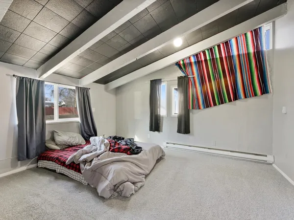 a bedroom with bed and a large window