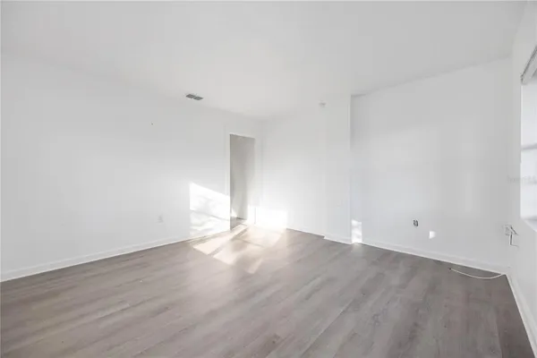 a view of an empty room with wooden floor