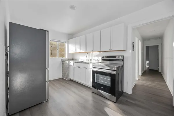 a kitchen with white cabinets and stainless steel appliances