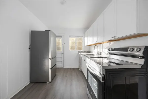 a kitchen with a refrigerator sink and cabinets
