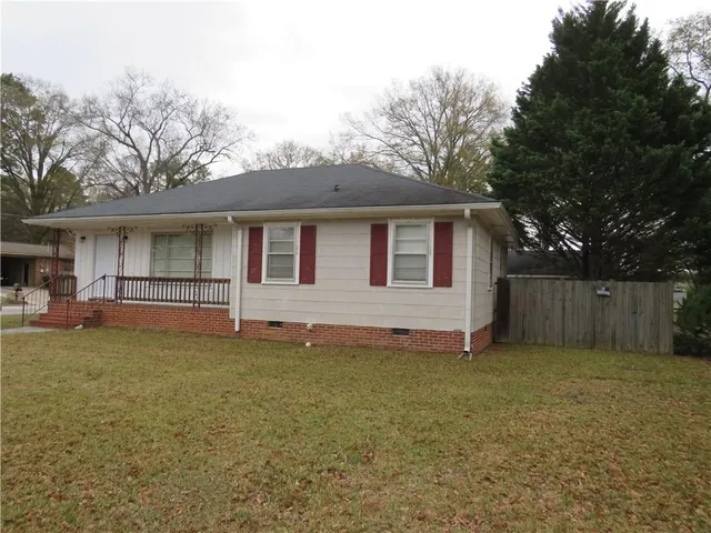 a view of a house with a yard and a large tree