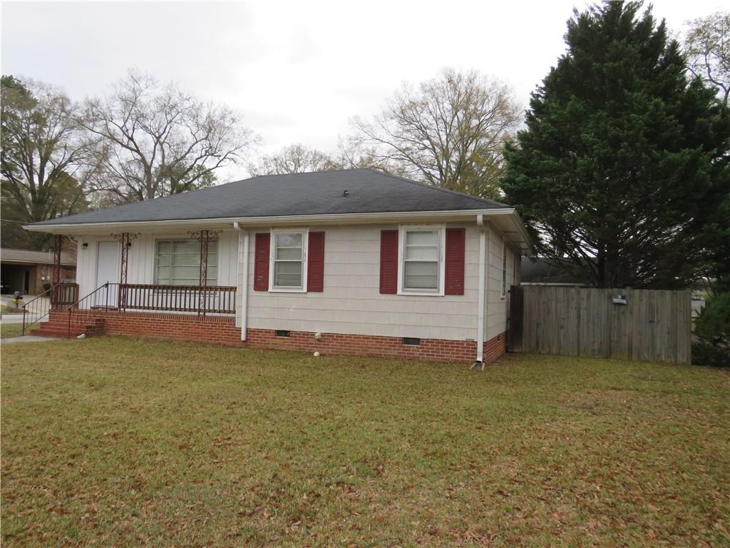 a view of a house with a yard and a large tree