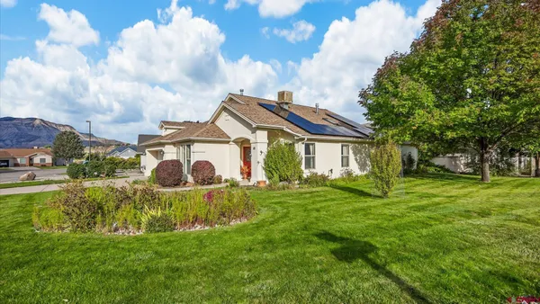 a view of a house with a big yard and a fountain