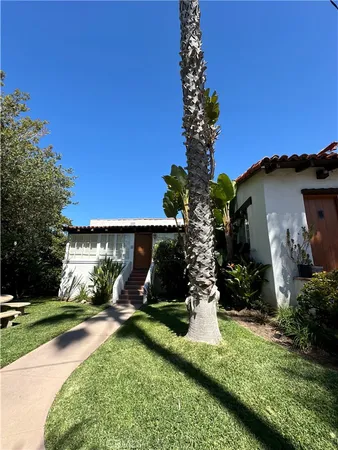a view of a house with a yard and potted plants