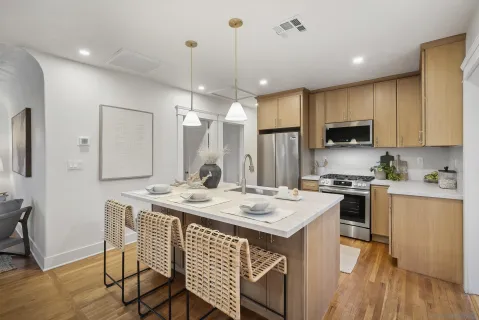 a kitchen with a sink stove cabinets and wooden floor