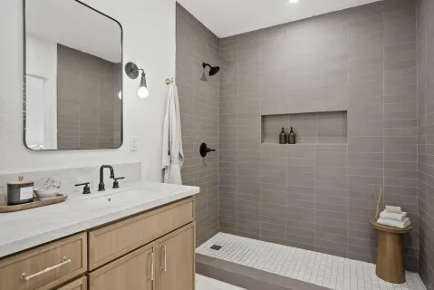 a bathroom with a sink a toilet a shower and a mirror