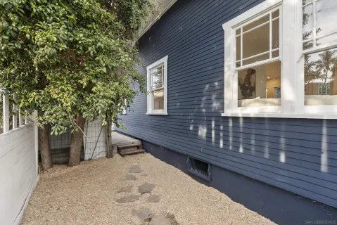 a view of a house with a yard and large tree