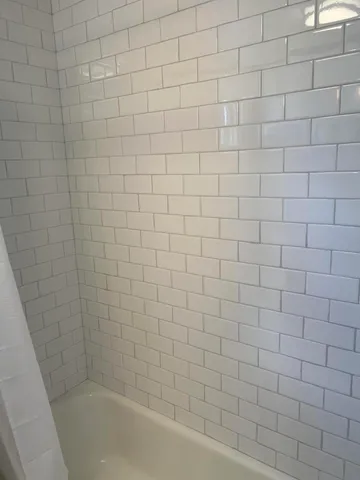 a bathroom with a white bathtub and a shower