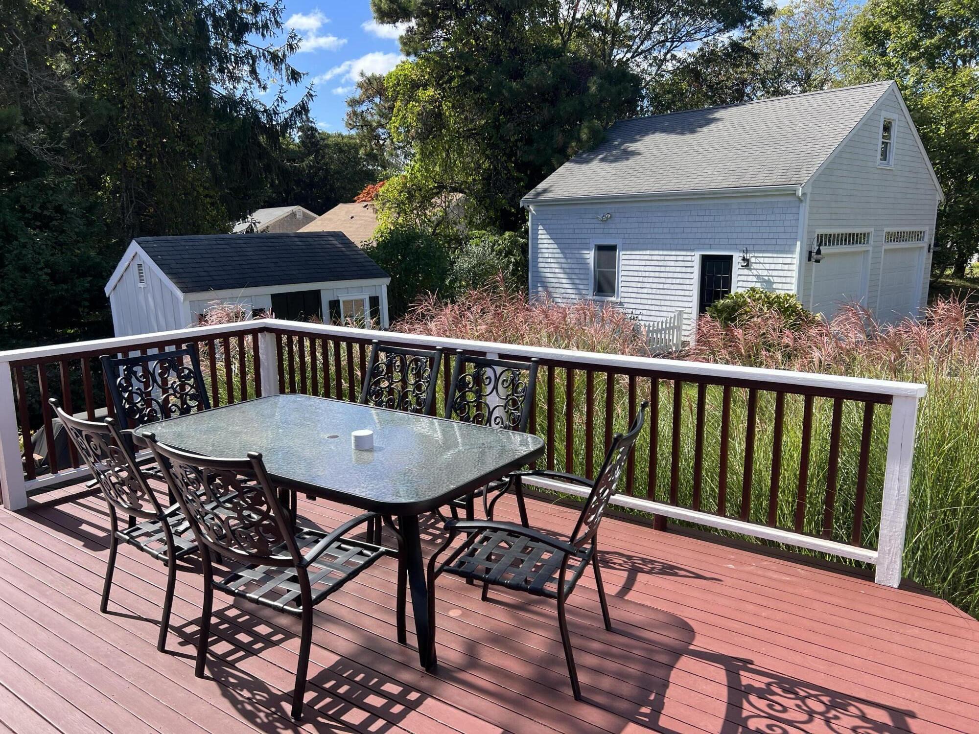 69 Joan Road Barnstable, MA 02632 - Photo 5 of 26 a view of a patio with table and chairs with wooden floor and fence