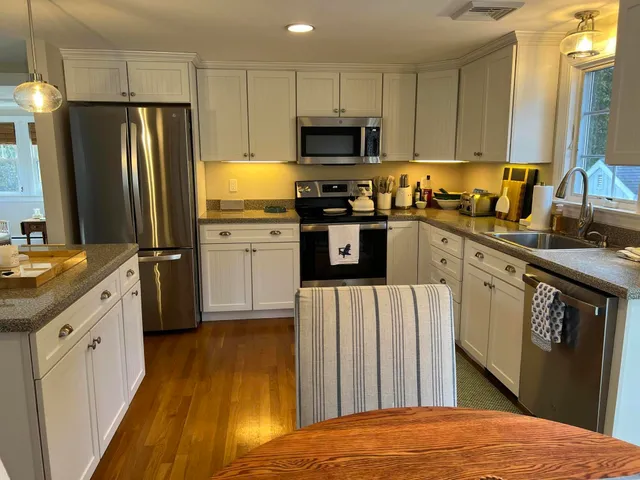 a kitchen with granite countertop a refrigerator stove and sink