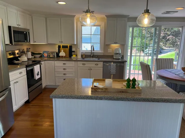 a kitchen with kitchen island granite countertop a stove a sink and a granite counter tops