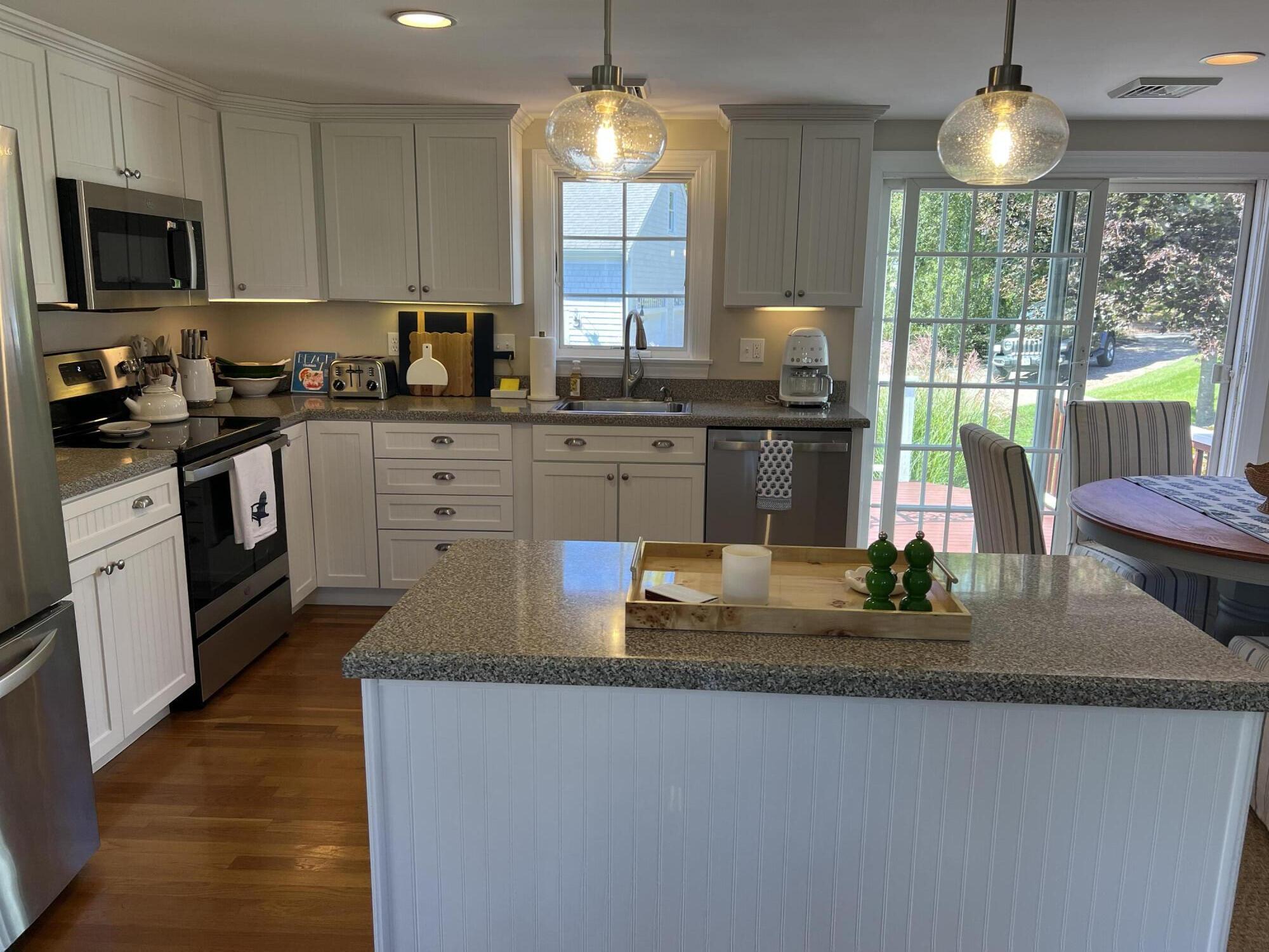 69 Joan Road Barnstable, MA 02632 - Photo 9 of 26 a kitchen with kitchen island granite countertop a stove a sink and a granite counter tops