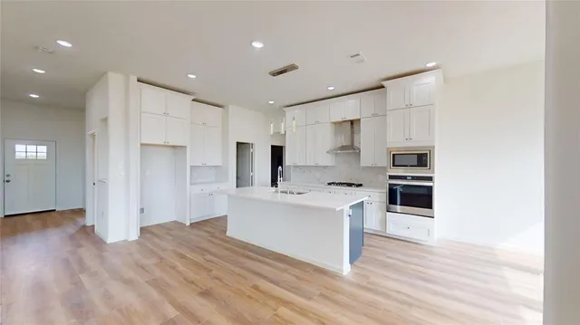 a kitchen with stainless steel appliances a sink and a refrigerator