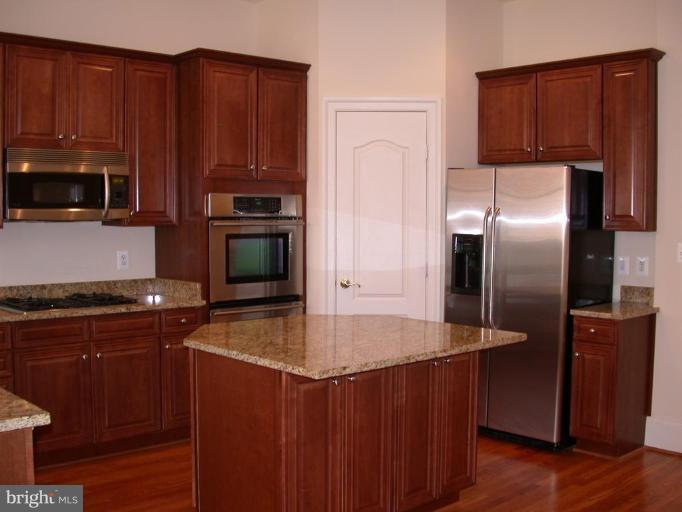 1730 Carpenter Road Alexandria, VA 22314 - Photo 4 of 20 a kitchen with granite countertop a refrigerator stove and microwave