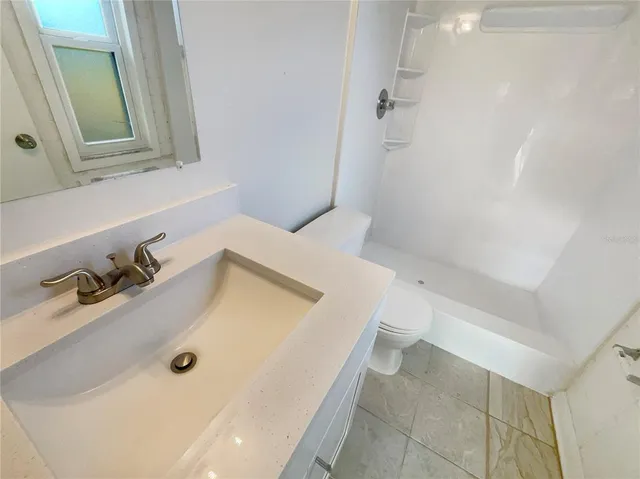 a bathroom with a tub sink and mirror