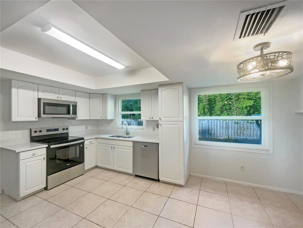 1911 Rambling Lane Brandon, FL 33510 - Photo 10 of 29 a kitchen with stainless steel appliances granite countertop a stove sink and microwave