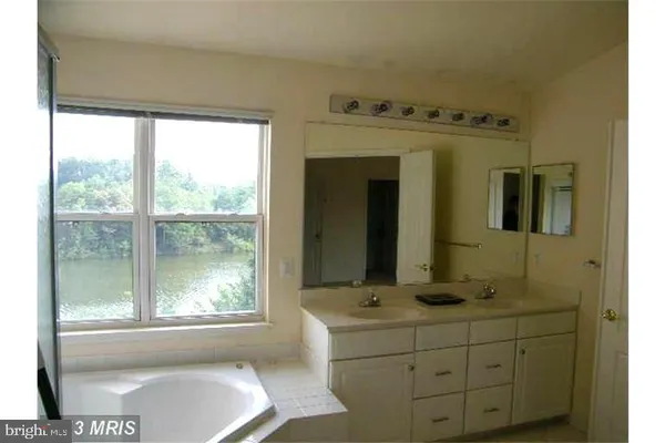 a bathroom with a sink mirror and a bathtub