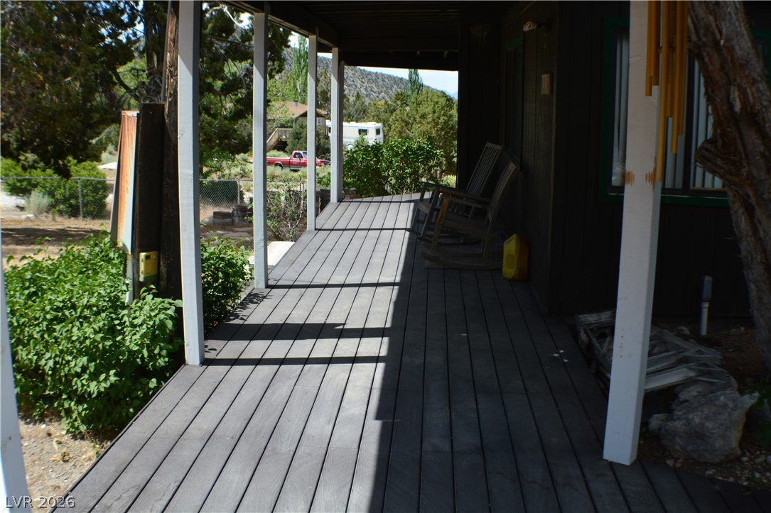 1321 Trout Canyon Road Las Vegas, NV 89124 - Photo 5 of 50 A long, inviting wooden porch offers a peaceful retreat with scenic views of distant hills.