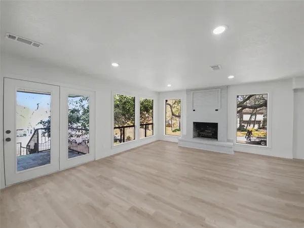 a view of an empty room with a window and fire place