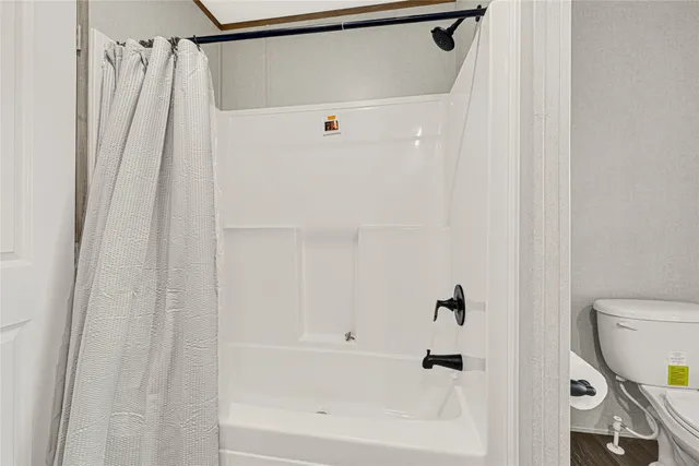 a bathroom with a shower curtain and a toilet