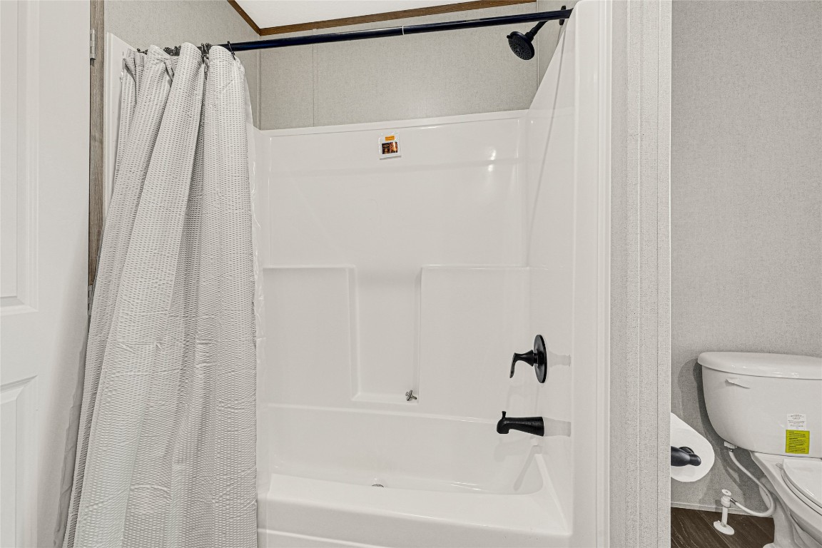 718 Main Street Anahuac, TX 77514 - Photo 19 of 26 a bathroom with a shower curtain and a toilet