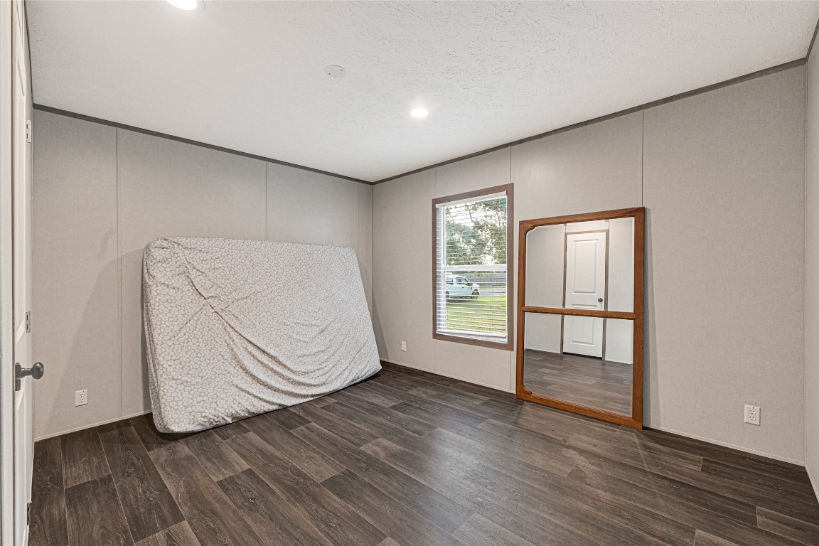 718 Main Street Anahuac, TX 77514 - Photo 20 of 26 an empty room with wooden floor and windows