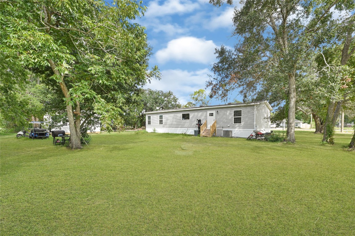 718 Main Street Anahuac, TX 77514 - Photo 26 of 26 a front view of a house with a garden and trees