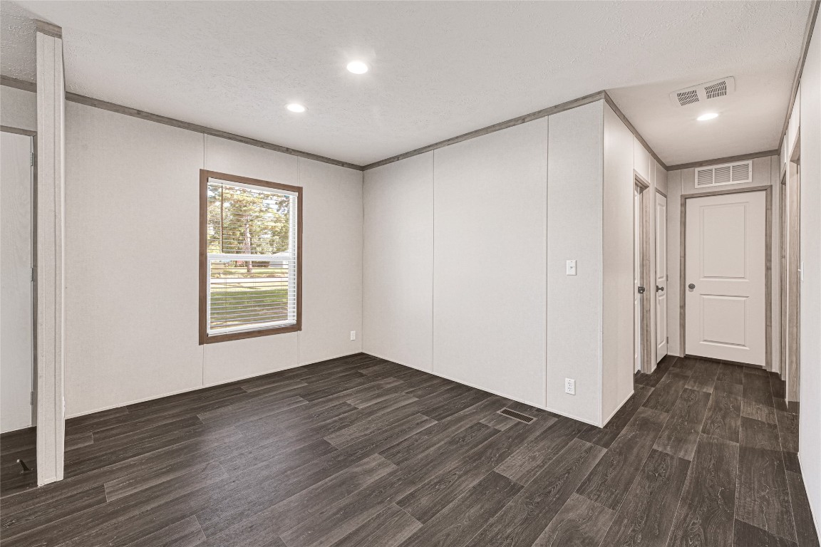 718 Main Street Anahuac, TX 77514 - Photo 7 of 26 a view of an empty room with wooden floor and a window