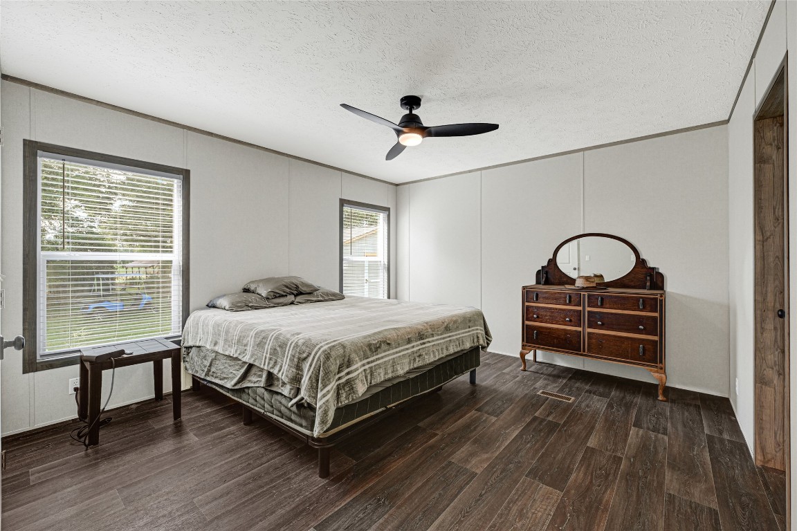 718 Main Street Anahuac, TX 77514 - Photo 9 of 26 a bedroom with a bed next to a window with a flat tv screen