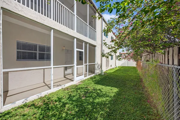 a view of backyard with large trees and plants
