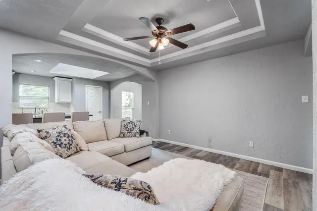 a living room with furniture and a ceiling fan