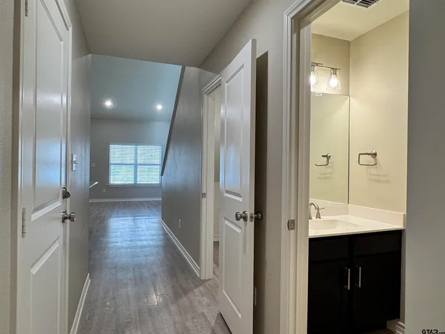 a view of a hallway with wooden floor