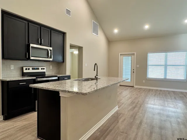 a kitchen with a refrigerator and a stove top oven