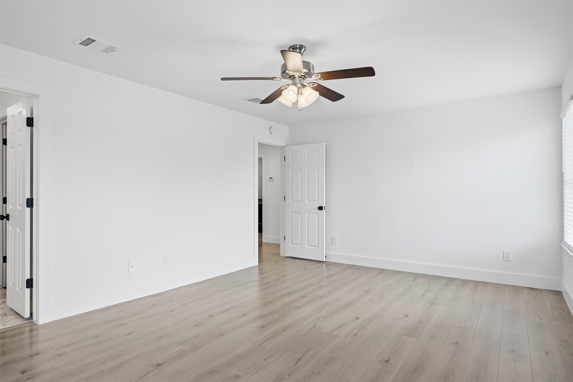 6708 Panda Royle Drive Del Valle, TX 78617 - Photo 25 of 40 an empty room with wooden floor ceiling fan and window