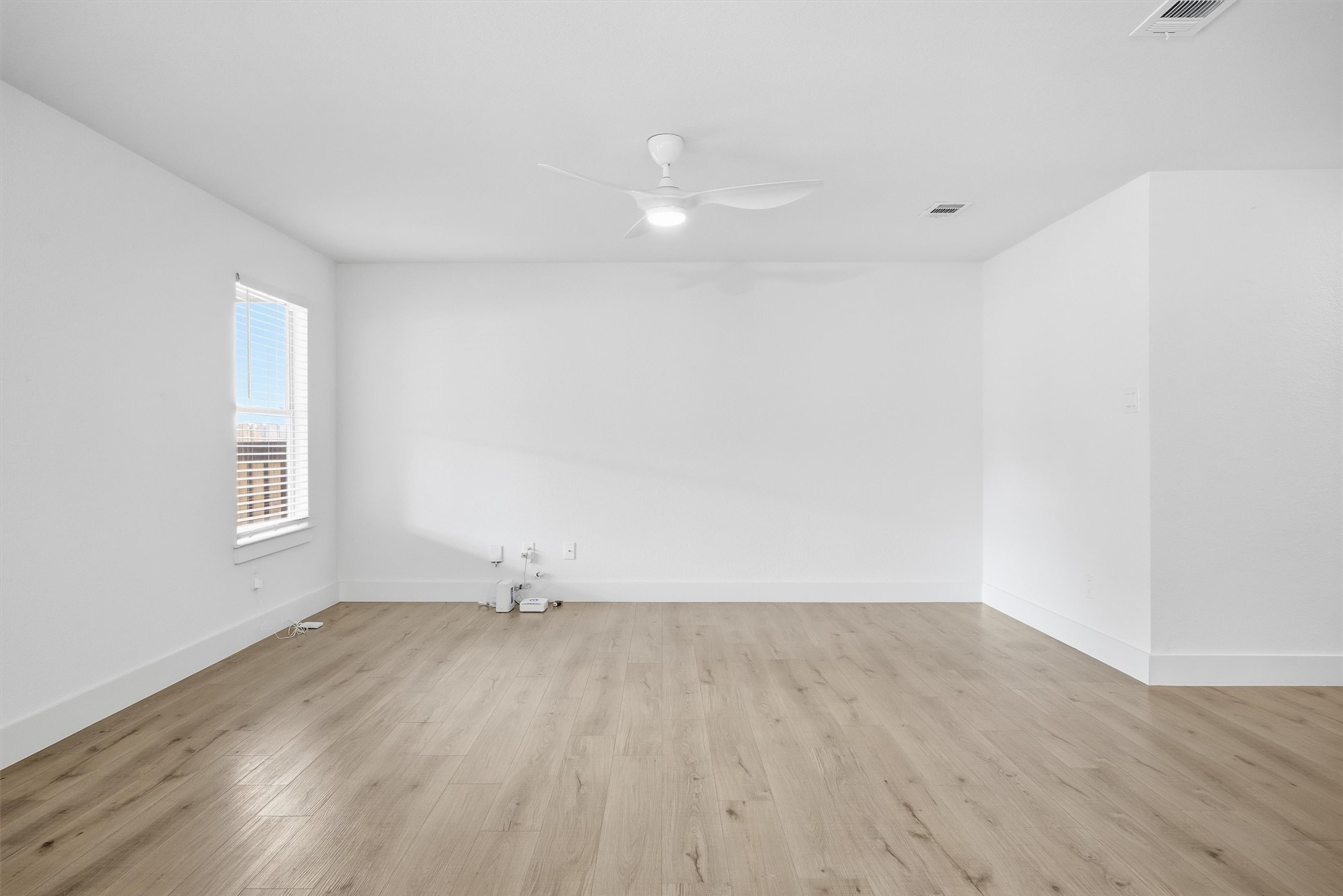 6708 Panda Royle Drive Del Valle, TX 78617 - Photo 6 of 40 an empty room with wooden floor and windows