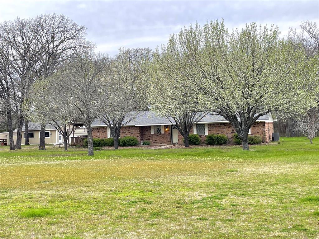 a front view of a house with a yard and trees