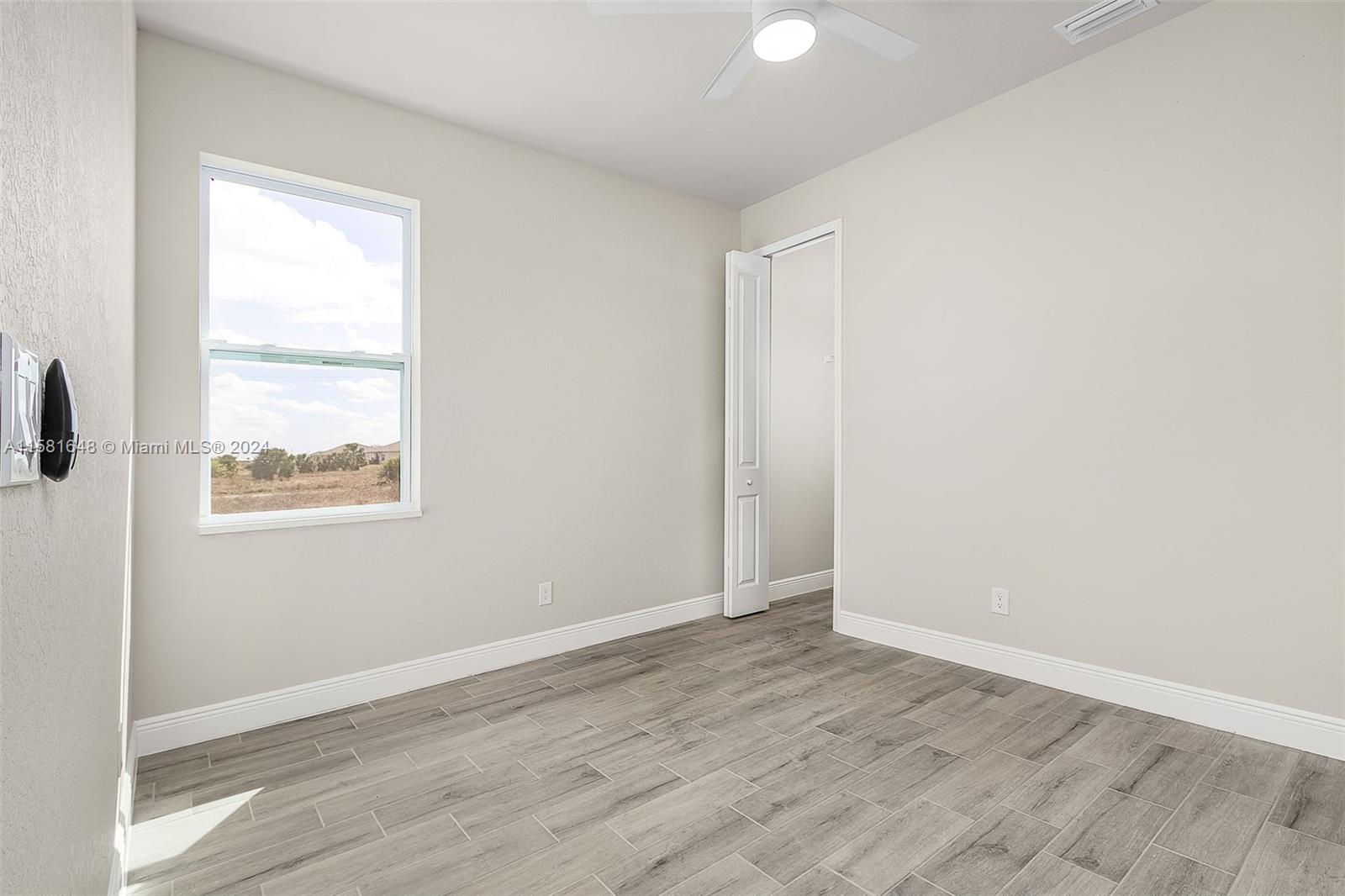 8035 Melody Circle LaBelle, FL 33935 - Photo 18 of 20 an empty room with wooden floor and windows