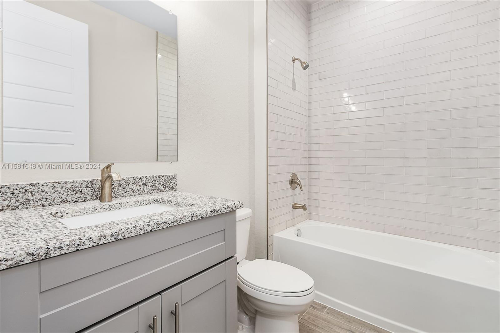 8035 Melody Circle LaBelle, FL 33935 - Photo 19 of 20 a bathroom with a granite countertop sink a toilet and bathtub