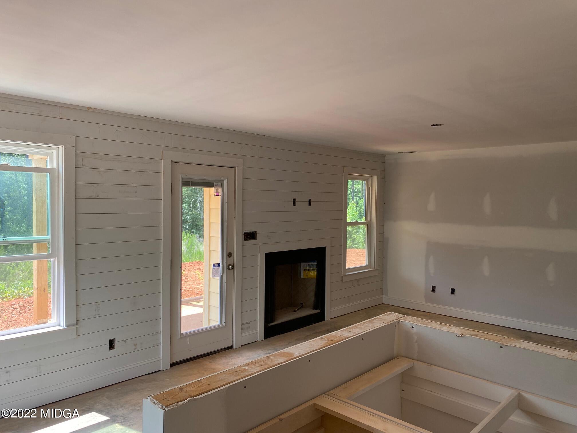 65 Jenkins Road Forsyth, GA 31029 - Photo 5 of 10 a view of an empty room with a fireplace and a window