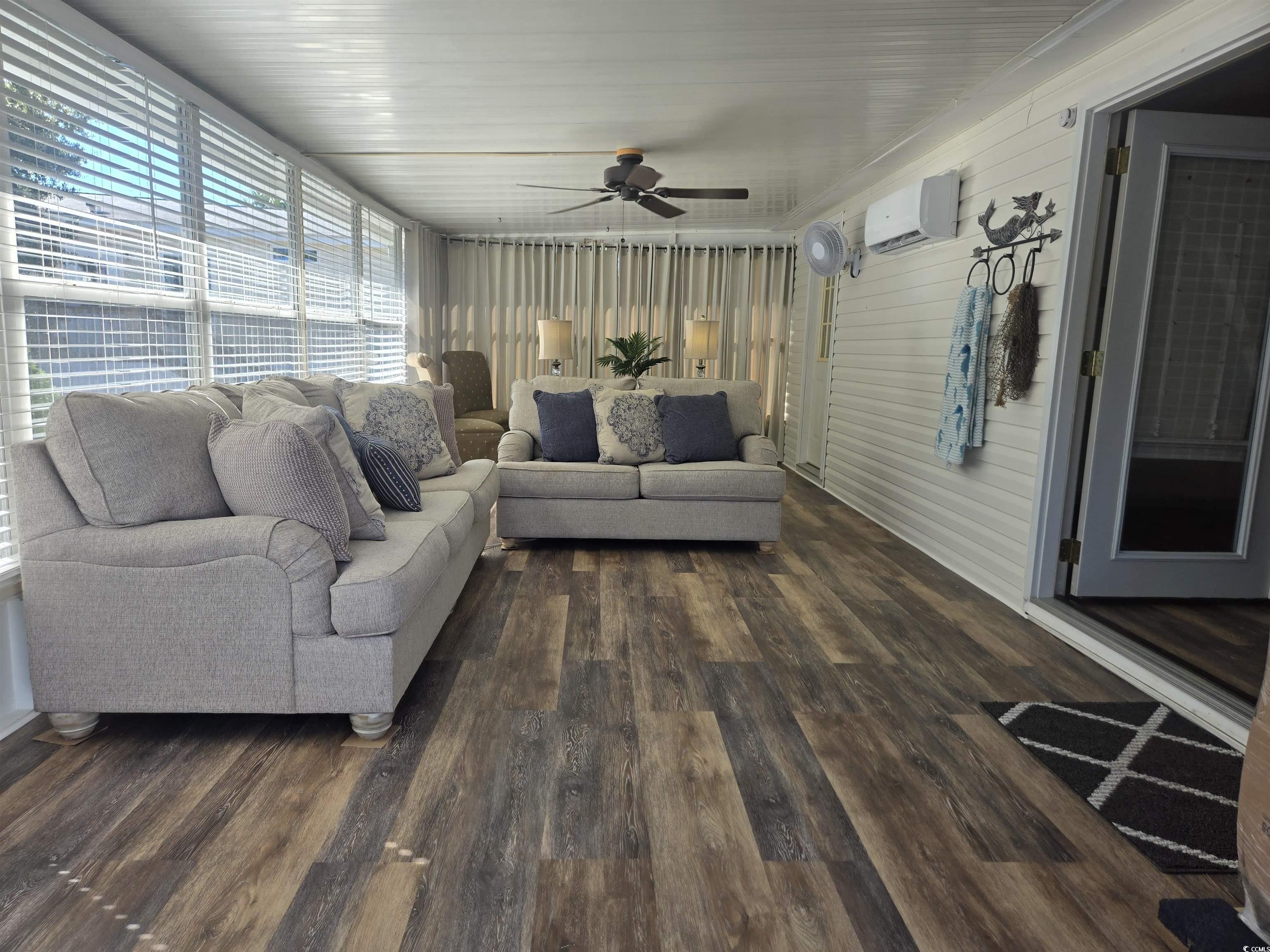 359 Lagoon Circle Murrells Inlet, SC 29576 - Photo 13 of 39 Living area featuring dark wood-style flooring, ceiling fan, and a wall unit AC